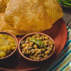 A close-up of our poori platter, showcasing the rich texture of our homemade chole and aloo sabzi. A true taste of Delhi.