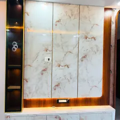 This floating TV unit combines a glossy white marble laminate with rich wood accents. The design includes a vertical display niche with built-in spotlights and is framed by warm LED backlighting.