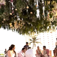 A beautiful moment under the lush floral canopy of the seaside mandap, with chandeliers adding a touch of elegance to the natural setting.