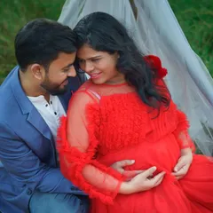 An intimate close-up from an outdoor maternity session. The couple shares a quiet moment, surrounded by nature, with the mother-to-be glowing in a vibrant red gown. These are the simple, heartfelt memories I love to capture.