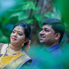 A lovely candid of a couple, framed by green leaves, looking towards their future together.