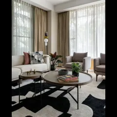 In the living room of Villa 93, we created a sanctuary of calm with a neutral color palette and abundant natural light. The design marries modern furniture with a bold, graphic rug, creating a space that is both sophisticated for entertaining and comfortable for quiet family moments.