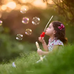 Lost in a world of bubbles. This beautiful, candid shot taken at sunset captures the simple joys of childhood in a serene and magical way.