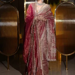 A full-length portrait showcasing a luxurious velvet shawl. The makeup is regal and polished, with a strong focus on sculpted features to match the grandeur of the outfit.