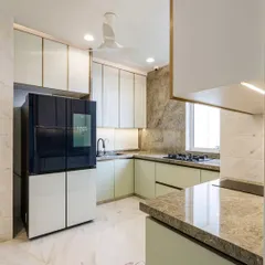 This wide shot showcases the L-shaped kitchen layout with its smart refrigerator and ample counter space. The under-cabinet lighting provides excellent task lighting while adding to the ambient glow.