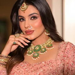 A close-up of this rosy, glowing bridal makeup. The soft pink tones on the eyes and cheeks, paired with a defined brow and nude-pink lip, create a look of subtle, modern grace.