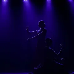 A silhouette of us in a moment of quiet connection on stage. The lighting plays a huge role in setting the mood for our performances, creating drama and beauty.