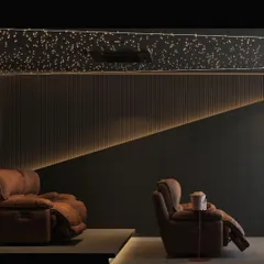 This view focuses on the luxurious seating and atmospheric lighting of the home theater. The plush recliners and the subtle glow from the recessed wall lighting create a comfortable and cinematic environment, perfect for enjoying your favorite films. (This media is part of the same project as ID 10, 11, 12).