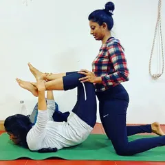 Practice reduces imperfection. In my classes, I often work with students one on one to help them with alignment, as seen here with a supported leg lift exercise to build core and leg strength.