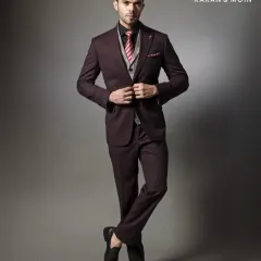 A full-length view of a deep burgundy three-piece suit. The contrasting waistcoat and patterned tie add a touch of personality, while the overall fit remains sharp and professional.