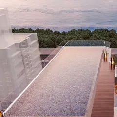 A view of the rooftop infinity pool, which appears to merge with the horizon. The warm wooden deck and ambient lantern lighting create a luxurious, resort-like feel high above the city.