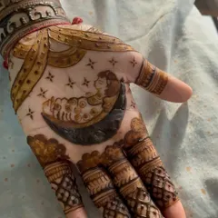 A sweet and special mehendi for a baby shower. The design features a baby sleeping on the moon, surrounded by stars, symbolizing the precious new life that is on its way.
