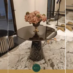 A sophisticated accent table with a smoked glass top and a textured marble pedestal base. We designed this piece to add a touch of custom charm and serve as an elegant centerpiece in a client's living area.