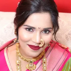 A close-up of a stunning Maharashtrian bride. She is wearing a traditional choker and a longer necklace, paired with the iconic crescent-shaped nath.