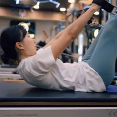 This ab curl with straps on the Reformer targets the upper abdominals while maintaining a stable pelvis. It’s a controlled movement that builds strength without straining the neck.