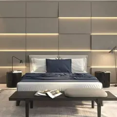 A minimalist and modern bedroom featuring a grey upholstered wall with integrated horizontal light strips. The simple, low-profile bed and dark side tables create a clean and calming environment.