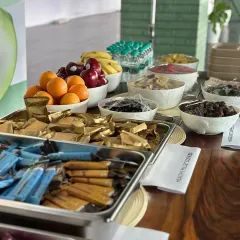 A closer look at the nutritious food we provide. The spread includes fresh fruits like oranges and apples, assorted nuts, and healthy multi-grain bars to nourish the body.
