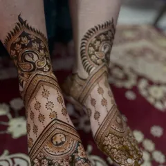 An elegant and asymmetrical design for the feet, with a large peacock motif on one side and flowing patterns on the other.