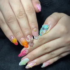 A vibrant and complex set featuring multi-colored 3D acrylic art. Each nail tells a different story with sculpted flowers, an octopus, and other unique elements, showing the creative possibilities of 3D design.