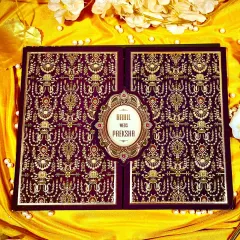 This invitation features a deep plum velvet finish with intricate gold brocade patterns, reminiscent of royal tapestries. The central emblem, holding the couple's names, makes it a truly opulent choice for a grand wedding.