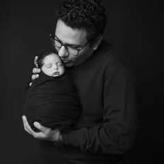 A father's gentle kiss for his newborn. I capture these quiet, tender moments in classic black and white to create timeless and emotional portraits that focus purely on the bond between parent and child.