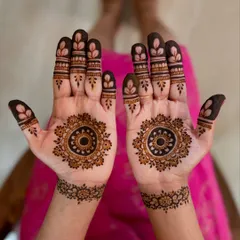 This minimal design for a bride's sister features a classic mandala on the palm with simple, leafy patterns on the fingertips. It's elegant and doesn't feel heavy.