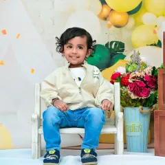 Celebrating a second birthday with a big smile. The large 'TWO' blocks are a great prop to mark this special milestone, and the cheerful yellow and green theme adds to the happy vibe.