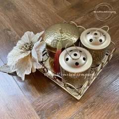 For those who love a touch of gold, this Diwali set is pure elegance. It features a hammered metal box and two intricate candle holders on a matching tray, designed to add a lasting sparkle to any home.