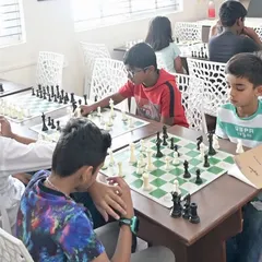 Students of various ages deeply engaged in their matches. This image captures the typical atmosphere of our group classes, fostering both competition and camaraderie.