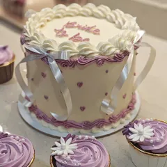 A closer look at the delicate piping and "Bride to be" message on this vintage-style cake. The silver ribbon adds a touch of elegance for a special bridal shower.