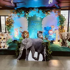 I brought the jungle to life for this first birthday party with a large stage setup. It features a variety of life-sized, friendly animal cutouts like an elephant, tiger, and zebra, all set against a lush green backdrop with a balloon arch to complete the safari theme.
