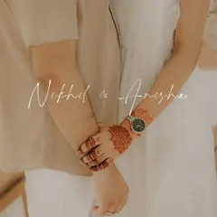 A close-up shot focusing on the couple's hands, showcasing the bride-to-be's beautiful henna and the watch that marks their time together. A simple, meaningful detail.