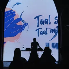 A silhouette shot that puts the focus on the VJ screen. The visuals, featuring the lyrics 'Taal Se Taal Mila', become a part of the performance, encouraging the crowd to sing along.