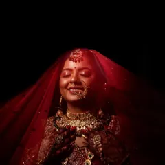 The moment a bride is lost in her own thoughts, just before the ceremony begins. I used dramatic lighting to highlight the rich red of her veil and the intricate details of her bridal jewellery, creating a timeless and soulful portrait.