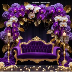 A truly royal stage design featuring a deep purple and gold color palette. I created a lush arch of purple and white orchids over a classic tufted velvet sofa, accented with ornate golden candelabras to create a rich and opulent setting for the couple.