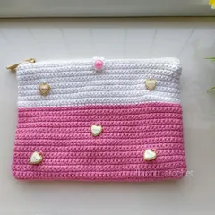A custom-made crochet pouch in pink and white. The client wanted something unique, so I added these adorable heart-shaped charms for a personal touch.