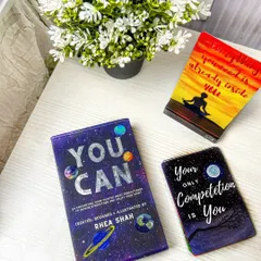 A cozy, lifestyle shot of motivational card decks on a bedside table with flowers. This helps customers imagine incorporating these products into their daily routines.