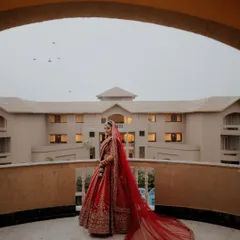 A bride's quiet moment of reflection. Prama, looking regal on her balcony in Puri, with her magnificent red veil trailing behind her. I craft these portraits to be as timeless as a painting.