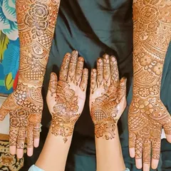 Coordinated designs for the bride and her bridesmaid. The bridesmaid's design is less dense but complements the bride's intricate pattern perfectly.