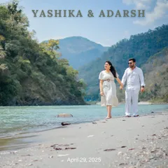 A beautiful save-the-date photo of a couple walking along the sandy banks of the Ganga in Rishikesh, dressed in elegant white.