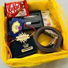 This bright and cheerful Rakhi hamper is presented in a yellow mesh basket. It contains a personalized wallet and rakhi, a belt, a pen set, and a KitKat chocolate.