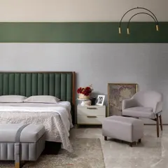 A detail shot of the bedroom's seating nook, with an elegant armchair and ottoman. Every corner is considered, providing quiet spots for reading or relaxing within the larger suite.