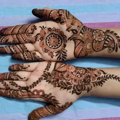 A simple and elegant party henna design from an Eid session. It features a small mandala on one palm and a classic paisley vine on the other.