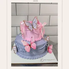 A two-tiered cake that brings a touch of whimsy to any party. With delicate lavender and pink frosting, intricate piping, and beautiful butterfly accents, this design is a favorite for birthdays and baby showers.
