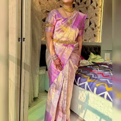 A full-length view of the bride in her beautiful lavender and gold silk saree. The makeup harmonizes with the traditional attire perfectly.