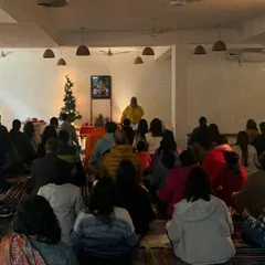 A wide view of our New Year's satsang, with our community gathered to welcome the year with positive intentions. The decorated tree in the background adds a festive, yet serene, touch to our spiritual gathering.