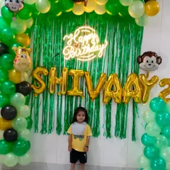 Welcome to the jungle! This jungle-themed birthday decoration features a lush green balloon arch, animal foil balloons like a monkey, giraffe, and lion, and a personalized name banner. It's a perfect adventure for a wild child's party.