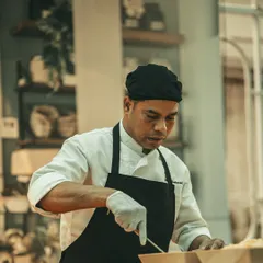 A chef concentrates on plating, showcasing the focus and craft that goes into each dish.