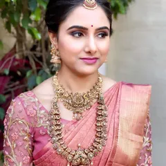 A side profile of Shwetha's Muhurtham look, highlighting the clean updo and the harmony between her makeup and traditional accessories.