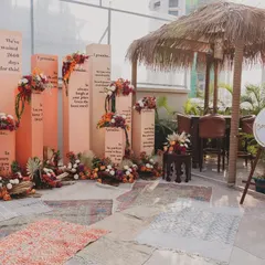 Our unique 'Promise Pillars' photobooth, set against a backdrop of boho rugs and a thatched-roof hut, creating a relaxed, festival-like atmosphere.